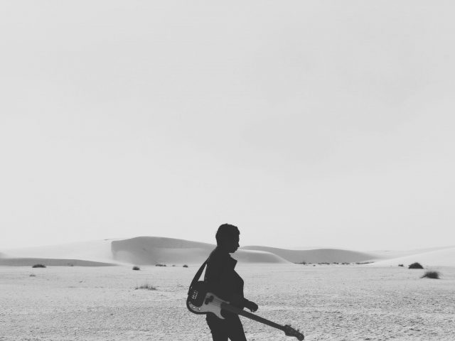 man with guitar in desert