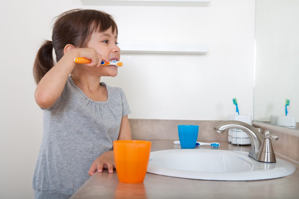 using kitchen sink brushing teeth